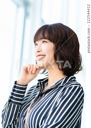 Smiling woman/businesswoman looking out the window 122544412