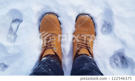 Tan boots in snowy landscape, view from above. 122546375