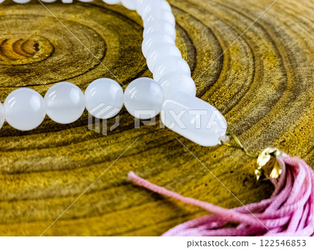 White moonstone rosary on a wooden background. Close-up. White moonstone rosary on a wooden background. Close-up. 122546853