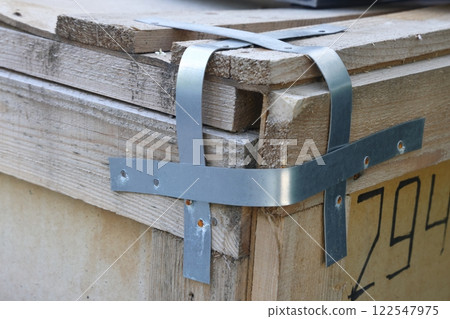 Packing straps close-up, metal strapping tapes, packing, securing loads, clamps, bolts and nuts. Packing straps close-up, metal strapping tapes, packing, securing loads, clamps, bolts and nuts. 122547975