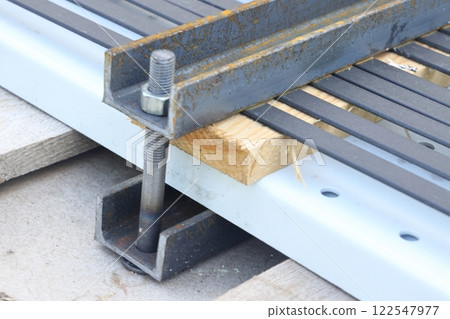 Packing straps close-up, metal strapping tapes, packing, securing loads, clamps, bolts and nuts. Packing straps close-up, metal strapping tapes, packing, securing loads, clamps, bolts and nuts. 122547977