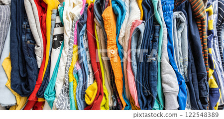 A very tall stack of folded colored clothes for charity, washing, ironing and sorting. 122548389