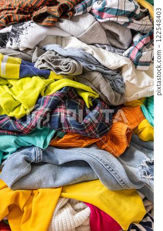 A Bunch of Different Clothes. Recyclable Textile Background. Sorting at Recycling Clothes A Bunch of Different Clothes. Recyclable Textile Background. Sorting at Recycling Clothes 122548403