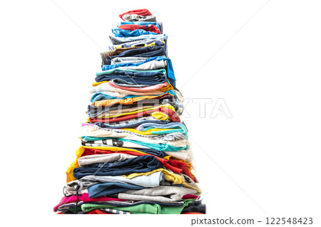 A very tall stack of folded colored clothes for charity, washing, ironing and sorting. A very tall stack of folded colored clothes for charity, washing, ironing and sorting. 122548423