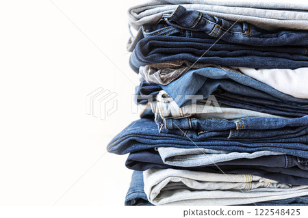 Stack of various shades of blue jeans on white background Stack of various shades of blue jeans on white background 122548425