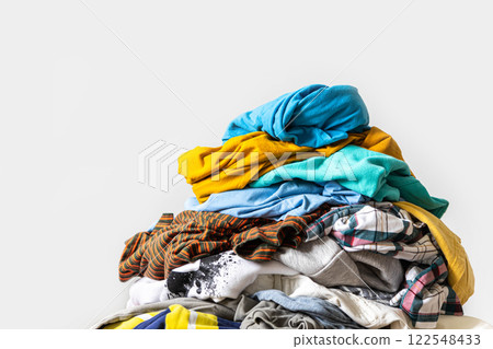 Pile of unfolded dirty clothes for laundry on the chair. Heap of used clothes for donation Pile of unfolded dirty clothes for laundry on the chair. Heap of used clothes for donation 122548433