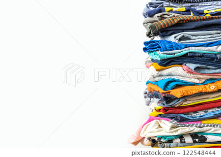 A very tall stack of folded colored clothes for charity, washing, ironing and sorting. A very tall stack of folded colored clothes for charity, washing, ironing and sorting. 122548444