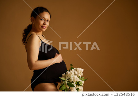 Pregnant Woman with Flowers in Studio Portrait 122548516