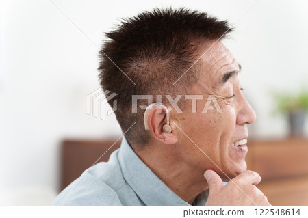 Senior man wearing a hearing aid Senior man wearing a hearing aid 122548614