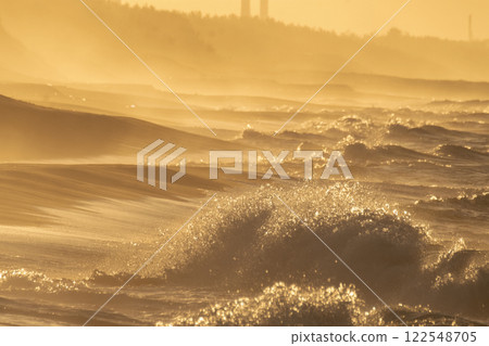 海灘上波濤洶湧，沐浴在夕陽的餘暉中 122548705