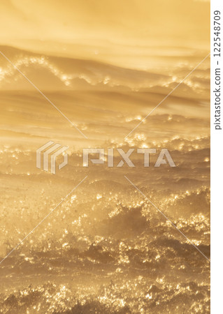 Rough waves on the beach dyed in the setting sun 122548709