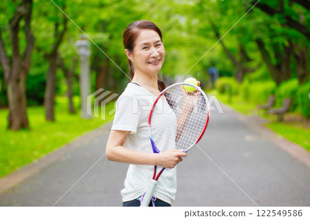 Senior woman standing with a tennis racket Senior woman standing with a tennis racket 122549586