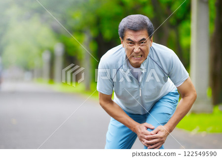 一名老人在公園伸展身體時膝蓋疼痛導致臉部扭曲 122549590