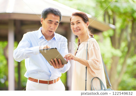Senior couple traveling looking at a tablet Senior couple traveling looking at a tablet 122549632