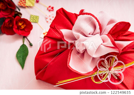 Red furoshiki wrapping and camellia 122549635