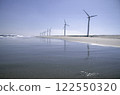 A calm coastline lined with windmills 122550320