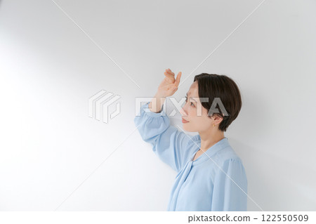 A woman in her 30s blocking the sunlight 122550509