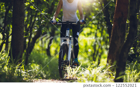 Mountain biking on summer forest trail Mountain biking on summer forest trail 122552021