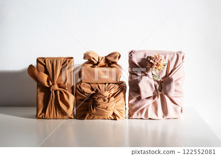 Gift boxes wrapped in reusable fabric, promoting waste reduction and sustainable gifting ideas. Gift boxes wrapped in reusable fabric, promoting waste reduction and sustainable gifting ideas. 122552081
