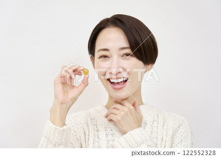 Woman holding throat lozenges on white background 122552328