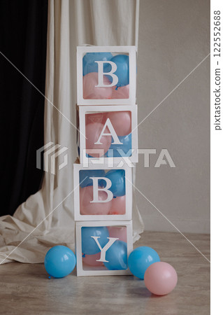 Decorations for a gender party in the form of transparent boxes with pink and blue balloons. 122552688