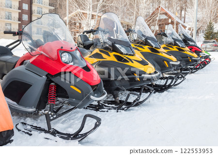 Parking of snowmobiles in a mountain village in winter 122553953