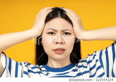 A girl of Asian appearance, on a yellow background. A girl of Asian appearance, on a yellow background. 122554124