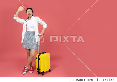 Asian girl with a suitcase, on a pink background. Asian girl with a suitcase, on a pink background. 122554138