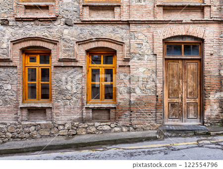 Historic Stone Building With Wooden Windows in a Cobblestone Street 122554796