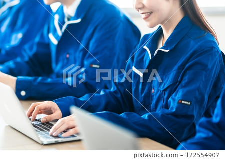 A middle-aged woman working at a transportation company typing on a computer, no face 122554907