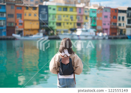 woman traveler visiting in Taiwan, female Tourist with backpack sightseeing at Keelung, Colorful Zhengbin Fishing Port. Popular landmarks and attractions near Taipei City.  Asia Travel concept 122555149