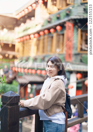 woman traveler visiting in Taiwan, female Tourist with backpack sightseeing at Jiufen Old Street village with Tea House background. Popular landmarks and attractions near Taipei City. Travel concept woman traveler visiting in Taiwan, female Tourist with backpack sightseeing at Jiufen Old Street village with Tea House background. Popular landmarks and attractions near Taipei City. Travel concept 122555153