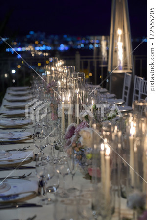 Tables set for an event party or wedding reception. Elegant table setting dinner in a restaurant. Glasses and dishes. 122555205