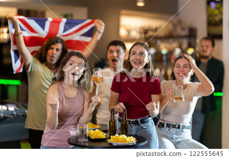 Emotional United Kingdom fans with national flag watch the match on TV with interest and actively comment Emotional United Kingdom fans with national flag watch the match on TV with interest and actively comment 122555645