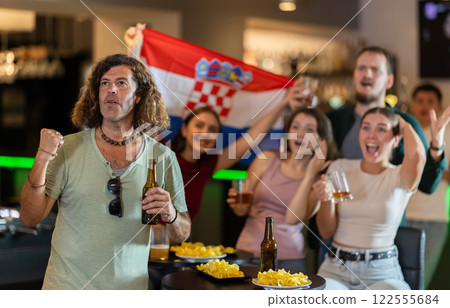 Sports supporters with flag of Croatia, rejoicing winning game with beer and snacks in pub Sports supporters with flag of Croatia, rejoicing winning game with beer and snacks in pub 122555684