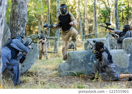 Team of paintball players attacks enemy at an army training ground Team of paintball players attacks enemy at an army training ground 122555901