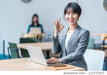 A businesswoman making an OK sign. 122555937