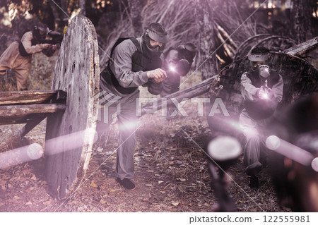 Impudent teams facing on battlefield in outdoor paintball arena during match Impudent teams facing on battlefield in outdoor paintball arena during match 122555981