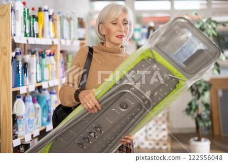 Woman choosing an ironing board 122556048