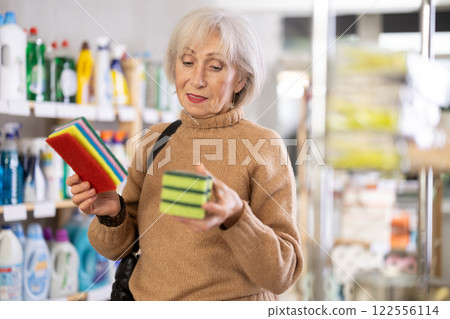 Positive mature woman choosing cleaning sponge in department store Positive mature woman choosing cleaning sponge in department store 122556114