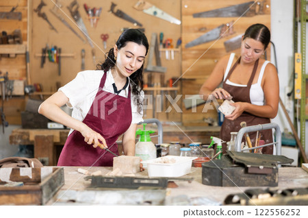 Girl is busy in carpentry workshop Girl is busy in carpentry workshop 122556252