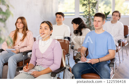 Group of high school students listening to lecture in auditorium 122556416