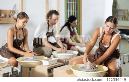 Girl working with pottery wheel 122556449