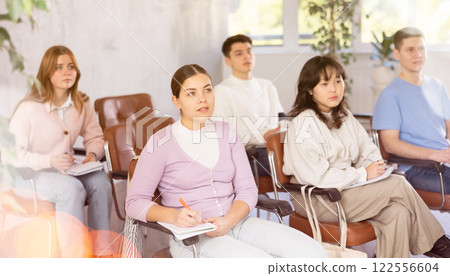 Young female student listening to lecture with focus 122556604