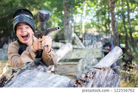 Woman fires a gun with passion while playing paintball 122556762
