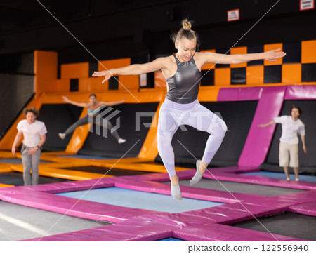 Adult woman trains jumping in trampoline center 122556940