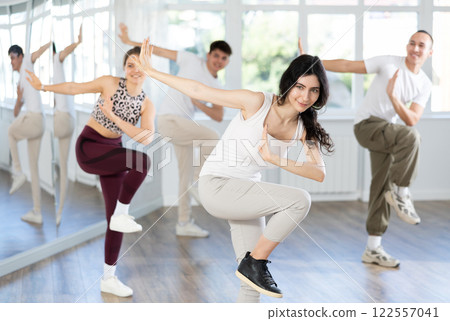 Happy dark-haired girl practicing vigorous zumba in fitness studio 122557041
