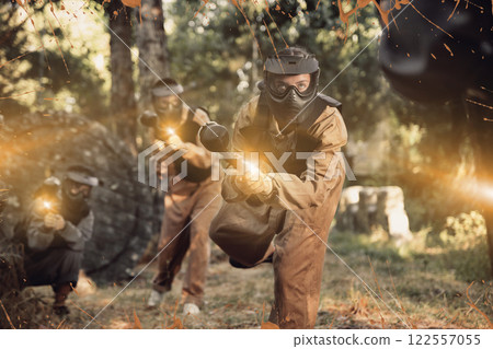 Young woman paintball player rushing through enemy lines 122557055