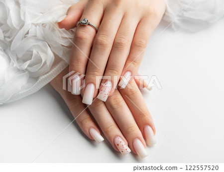 Bride showing her beautiful white nails and engagement ring 122557520