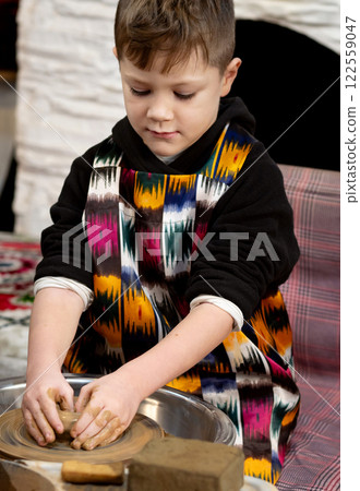 A boy creates a pot and decorating in a pottery workshop 122559047